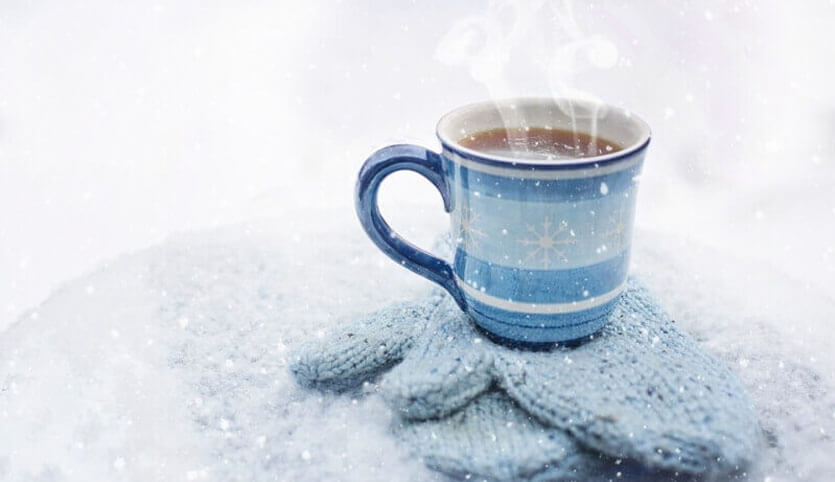 A hot drink atop a pair of gloves.