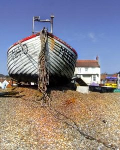 Old boat outside seaside home.