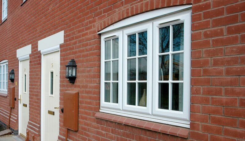 White casement windows on red brick home