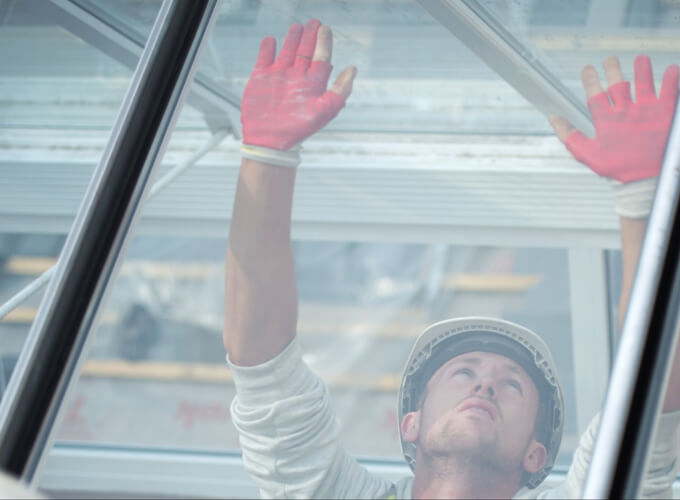 A person who identifies as a man installing glass.