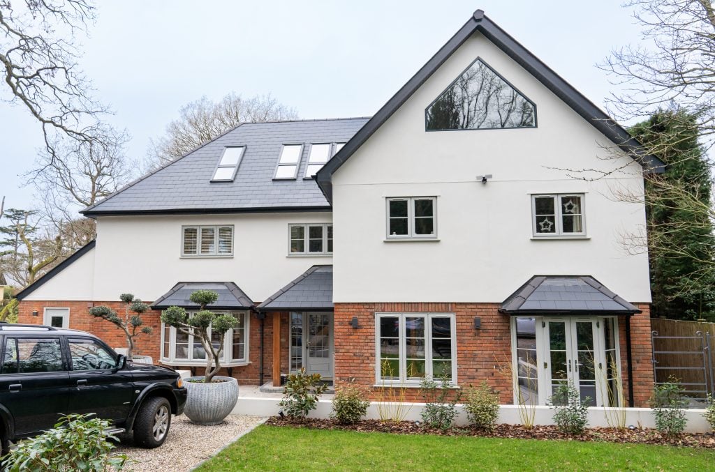 House with grey uPVC casement windows, French doors and bay windows