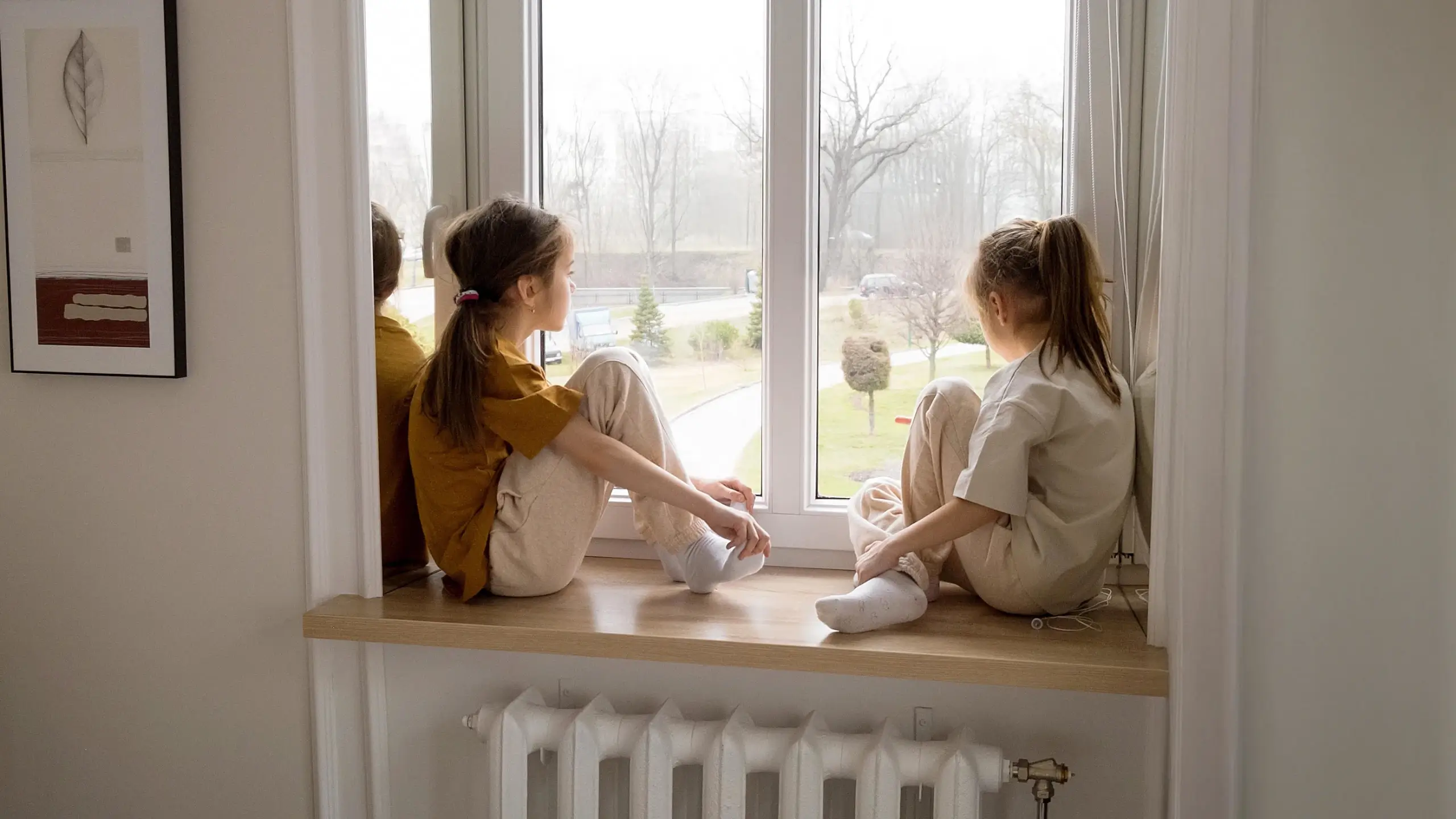 Two girls looking out a window